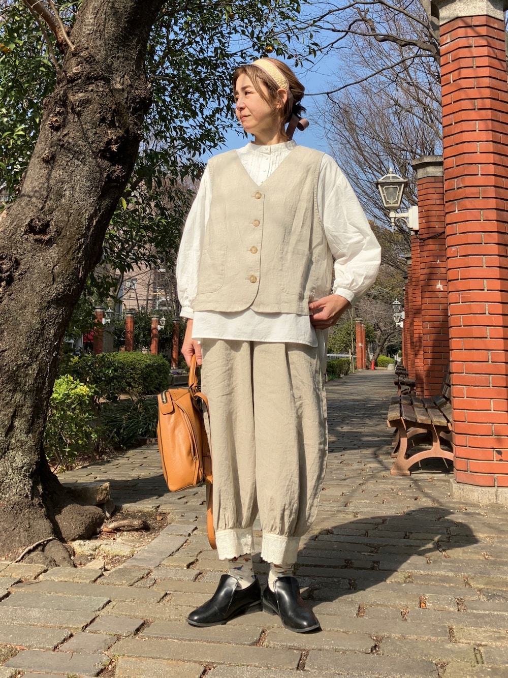 ベージュ系のベスト、ベージュ系のパンツ、ホワイト系のシャツ/ブラウスを着用したレディースの冬コーディネートの1枚目の写真