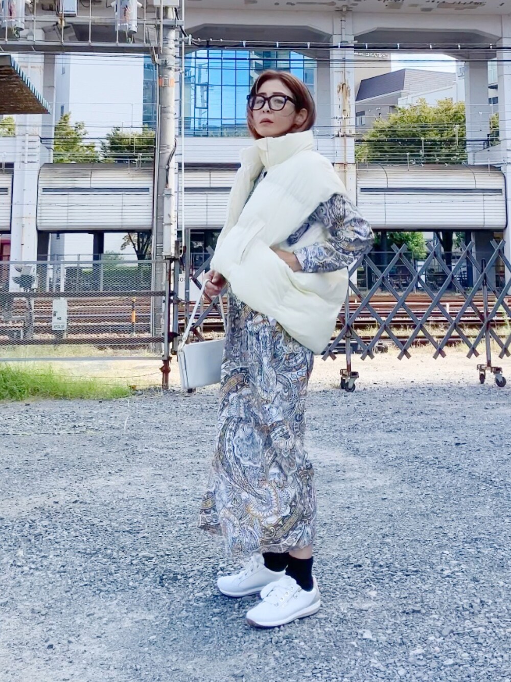 ブラック系のジャケット/アウター、ホワイト系のスニーカー、ホワイト系のショルダーバッグを着用したレディースの秋コーディネートの1枚目の写真