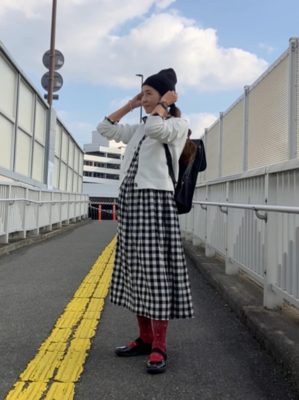 ブラック系のニットキャップ/ビーニーを着用したレディースの秋コーディネートの1枚目の写真