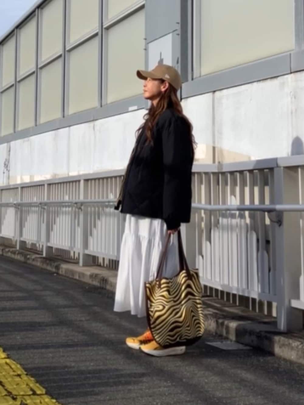 ブラック系のダウンジャケット/コート、ベージュ系のキャップを着用したレディースの冬コーディネートの1枚目の写真