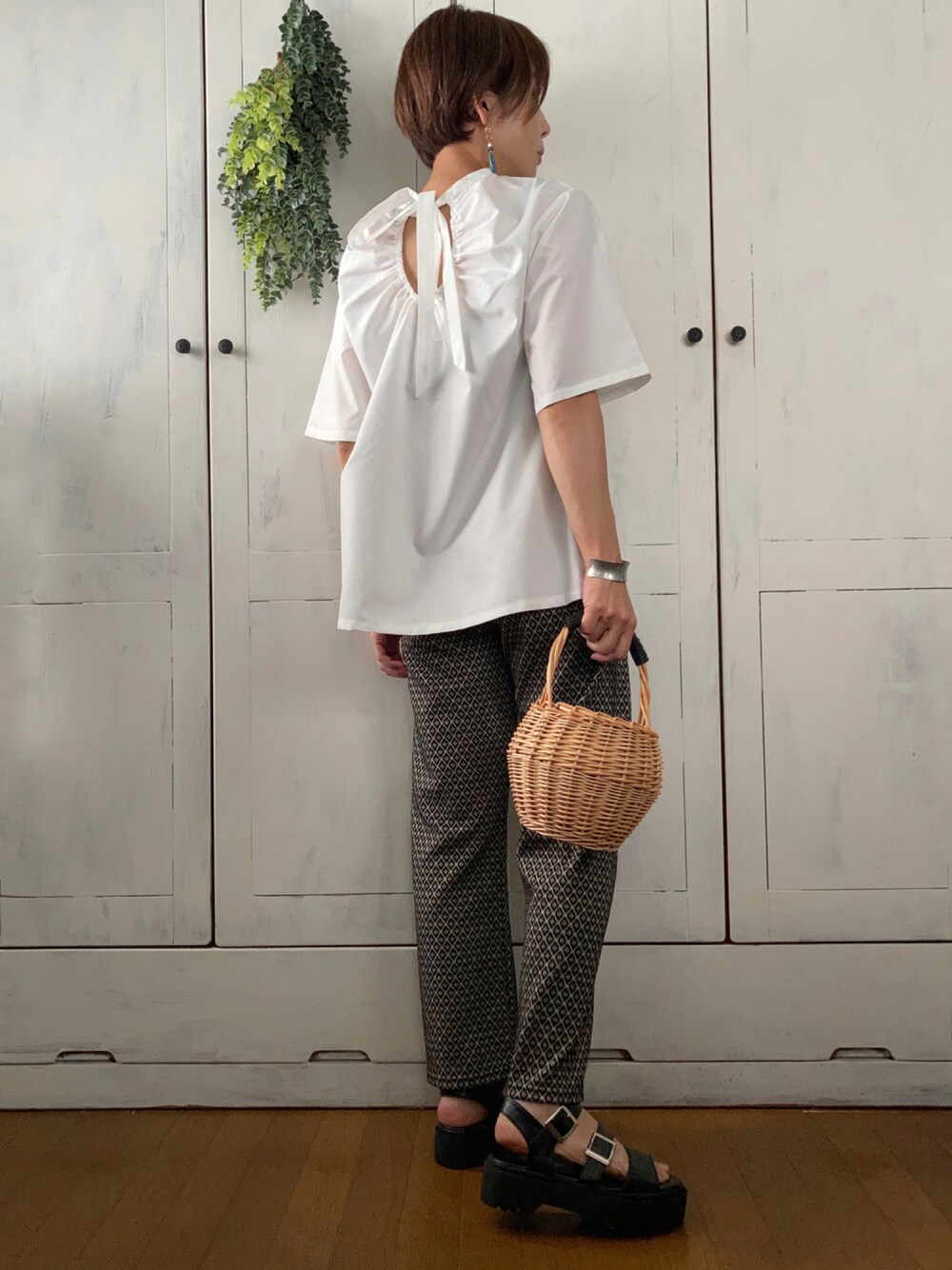 ホワイト系のシャツ/ブラウス、ブラック系のその他パンツ、ベージュ系のかごバッグを着用したレディースの夏コーディネートの1枚目の写真