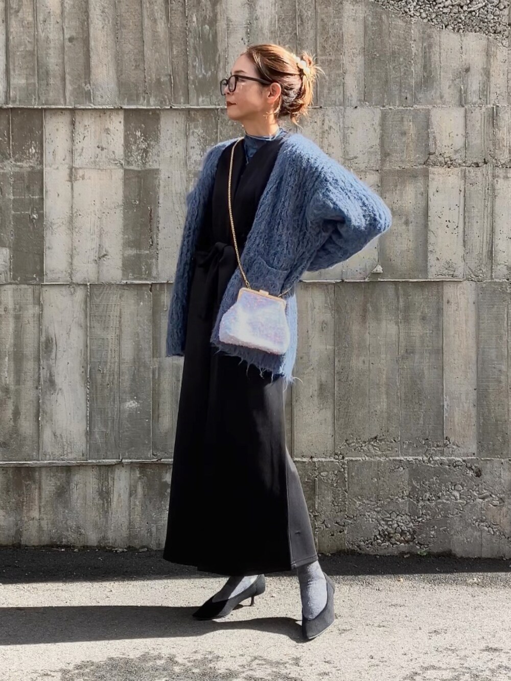 ブルー系のTシャツ/カットソー、ブラック系のジャンパースカート、ブルー系のカーディガン/ボレロを着用したレディースの冬コーディネートの1枚目の写真