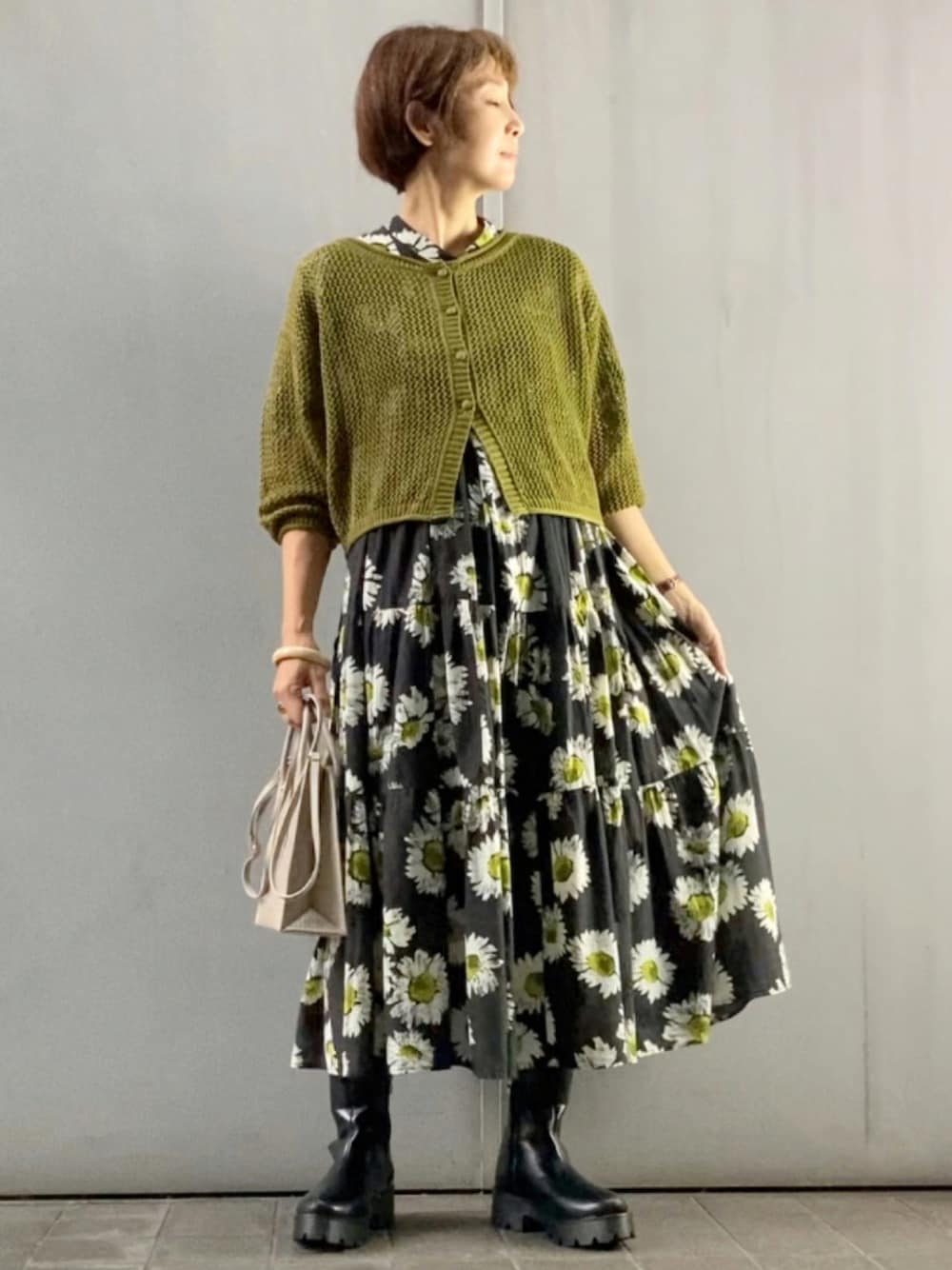 グリーン系のカーディガン/ボレロ、ブラック系のワンピース、ベージュ系のショルダーバッグを着用したレディースの夏コーディネートの1枚目の写真