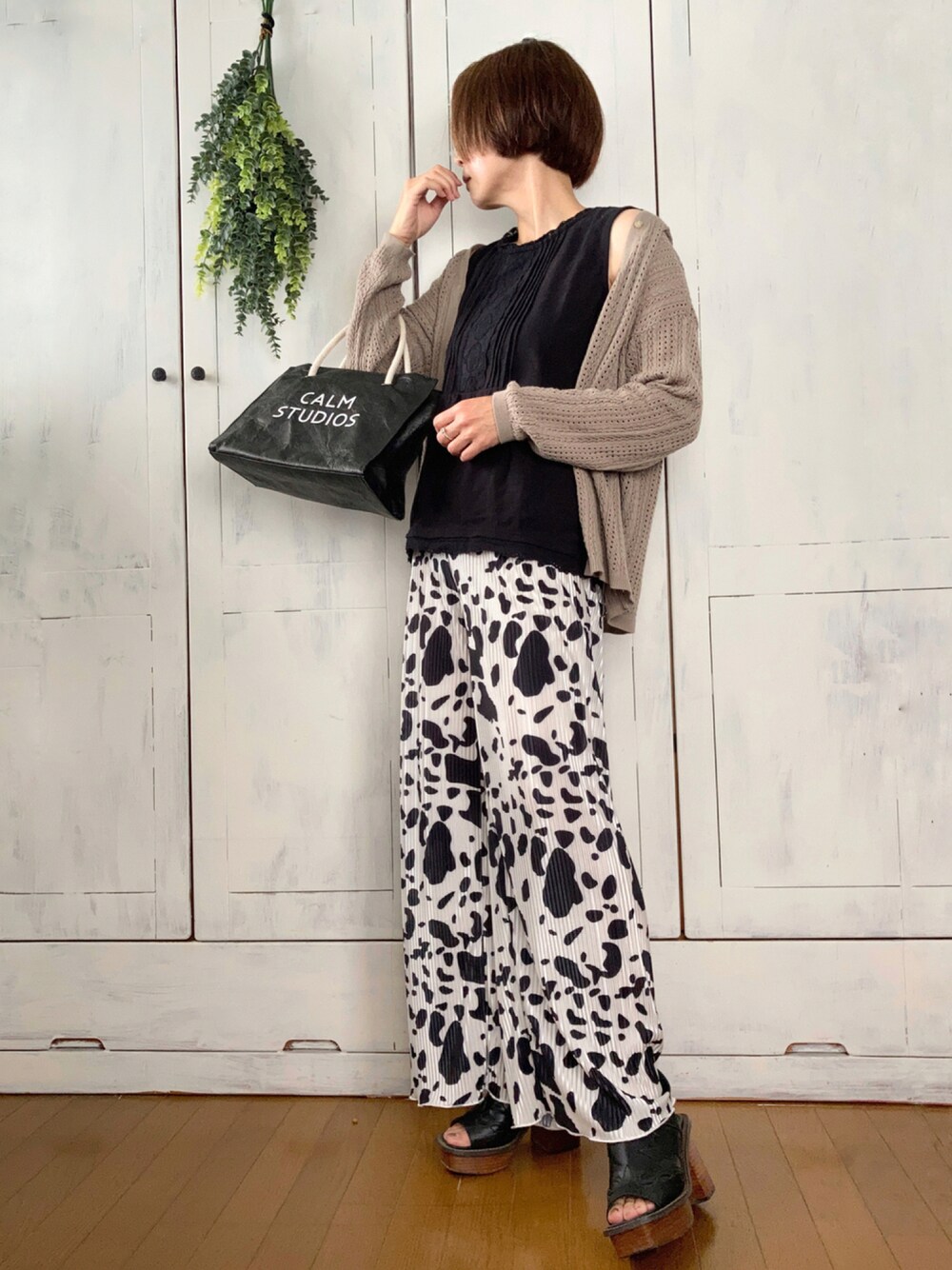 ホワイト系のその他パンツ、ブラック系のTシャツ/カットソー、ベージュ系のニット/セーターを着用したレディースの秋コーディネートの1枚目の写真