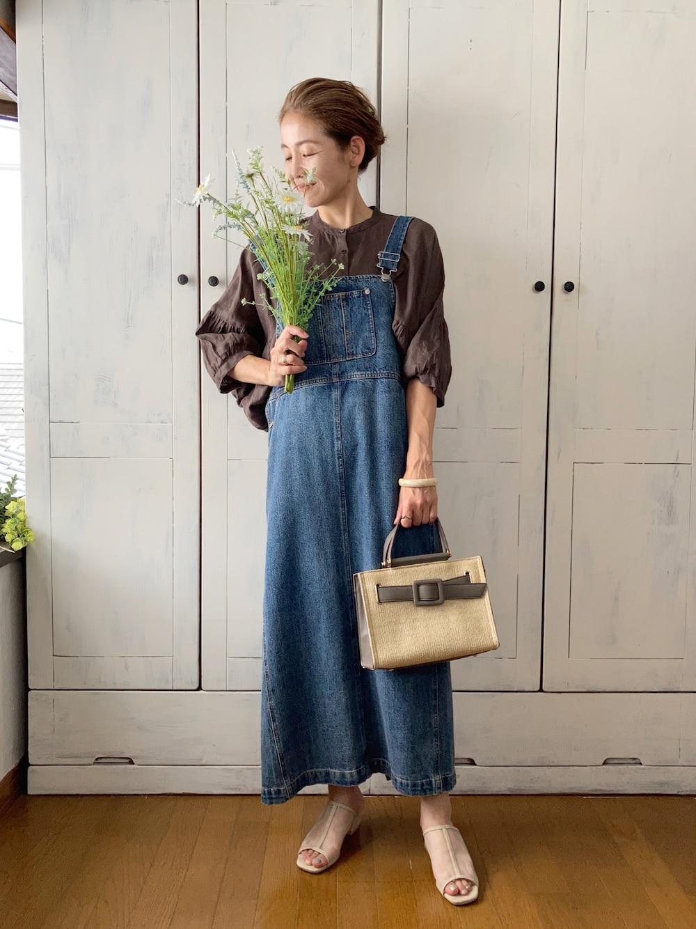 ブラウン系のトップス、ブルー系のサロペット/オーバーオール、グレー系のハンドバッグを着用したレディースの夏コーディネートの1枚目の写真