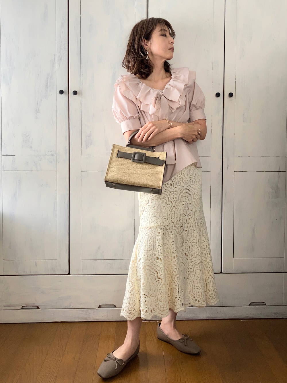 ベージュ系のシャツ/ブラウス、ホワイト系のスカート、グレー系のハンドバッグを着用したレディースの春コーディネートの1枚目の写真