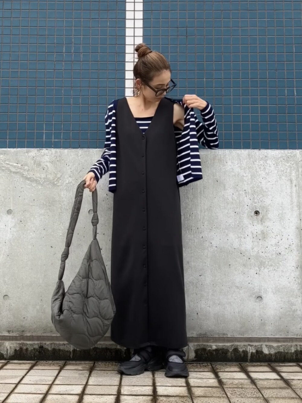 ブラック系のジャンパースカート、ブルー系のアンサンブル、ブラック系のシューズを着用したレディースの夏コーディネートの1枚目の写真