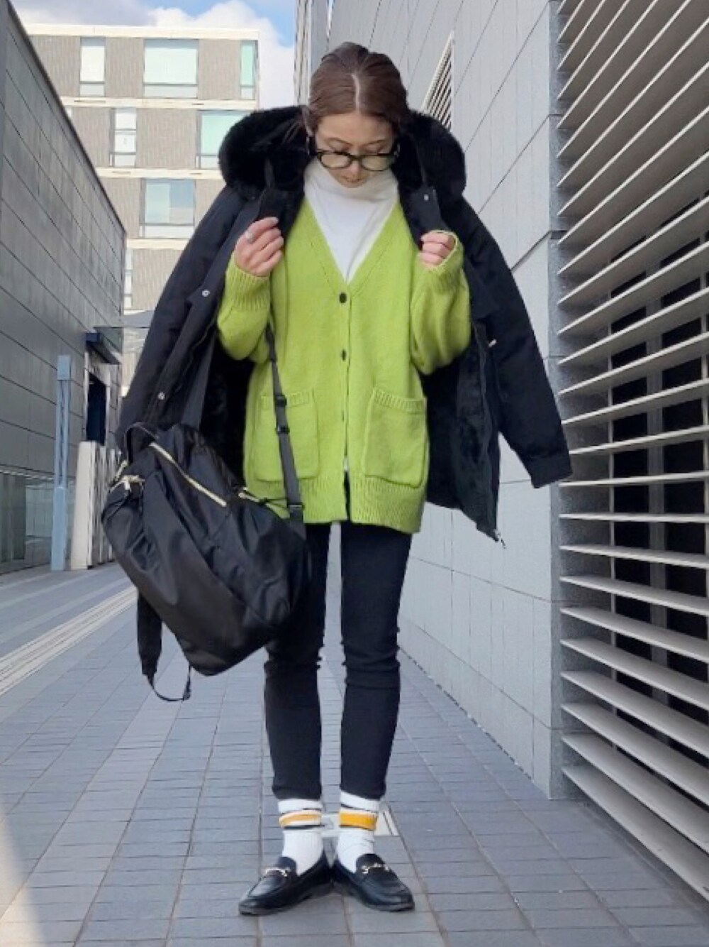 ブラック系のブルゾン、グリーン系のカーディガン/ボレロ、ブラック系のパンツを着用したレディースの冬コーディネートの1枚目の写真