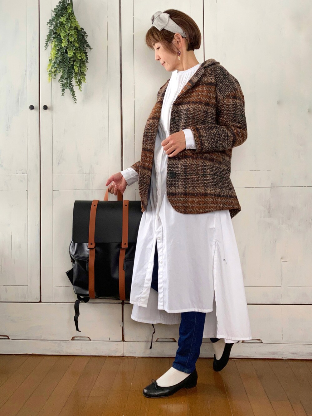 ブラウン系のテーラードジャケット、ホワイト系のワンピース、ブラウン系のバックパック/リュックを着用したレディースの秋コーディネートの1枚目の写真