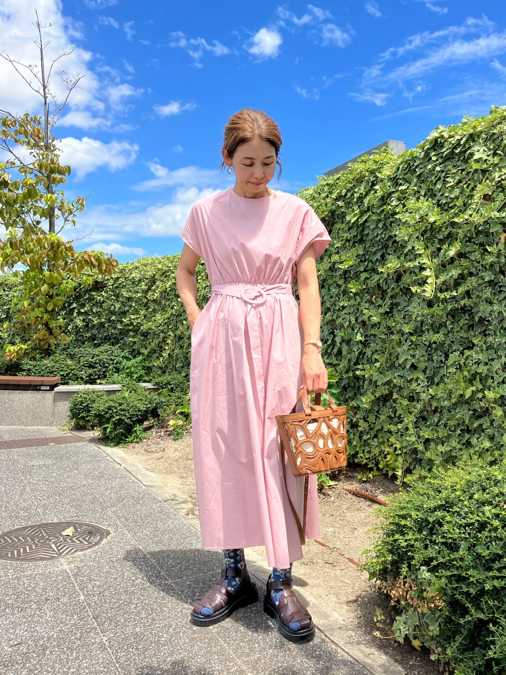 ピンク系のワンピース/ドレス、ブラウン系のサンダル、ブラウン系のバッグを着用したレディースの夏コーディネートの1枚目の写真