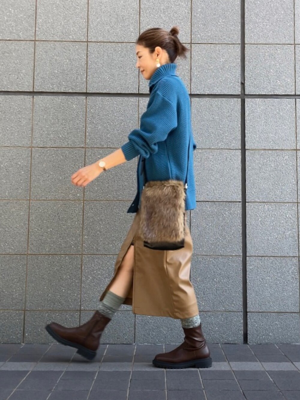 ブラウン系のブーツ、ブラウン系のスカート、ブルー系のニット/セーターを着用したレディースの秋コーディネートの1枚目の写真
