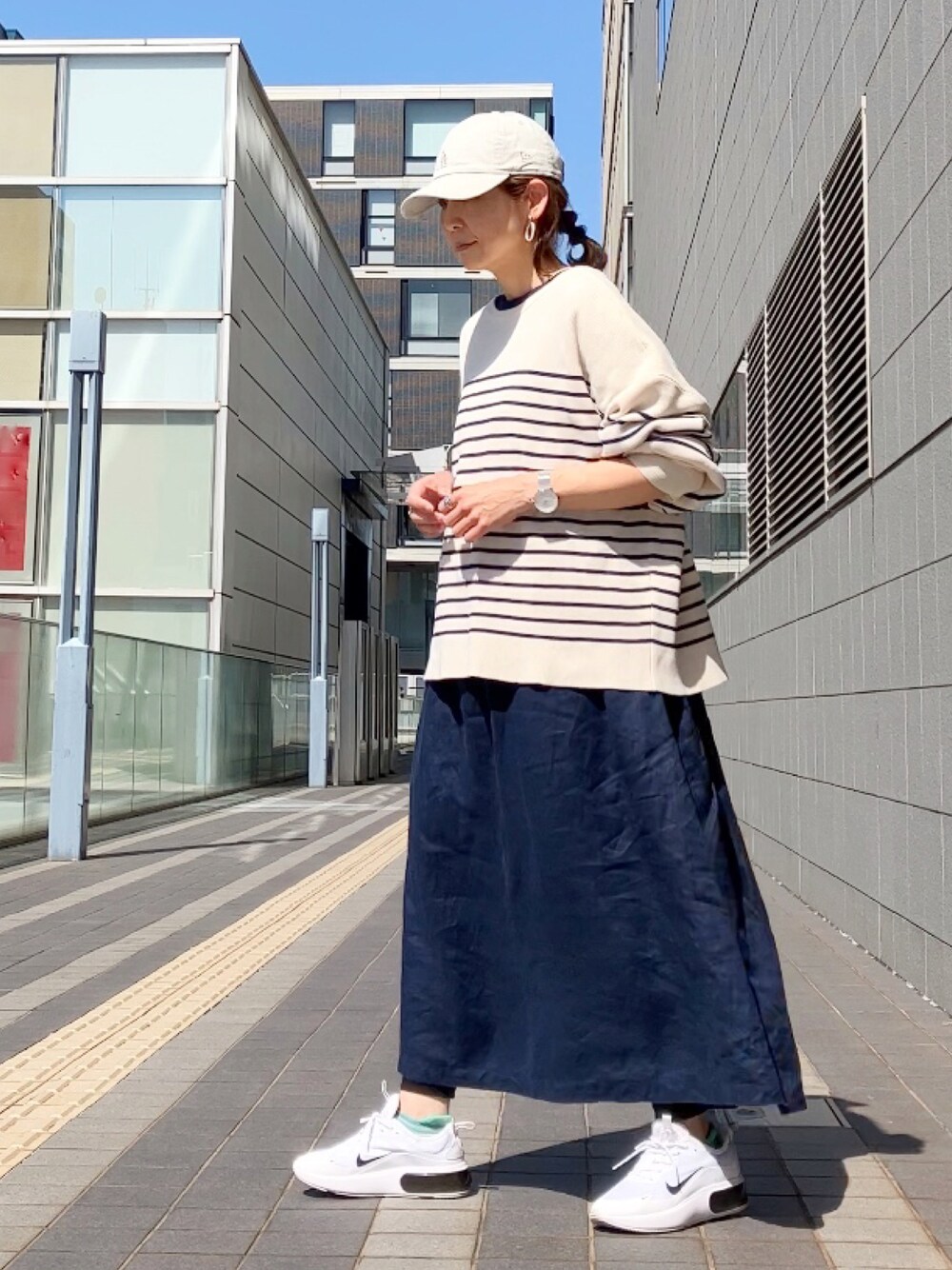 ブルー系のワンピース/ドレス、ブルー系のカーディガン/ボレロ、ベージュ系のキャップを着用したレディースの春コーディネートの1枚目の写真