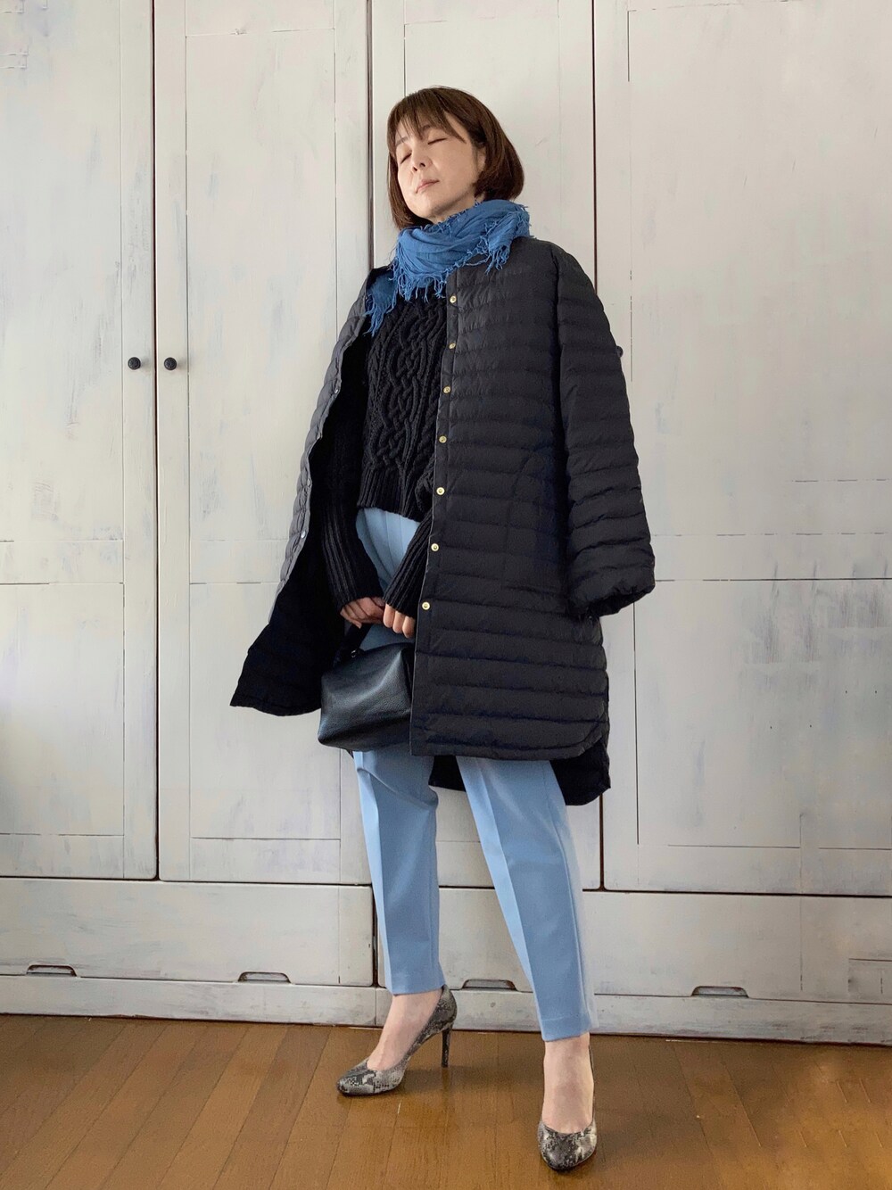 ブラック系のダウンジャケット/コート、ブラック系のニット/セーター、ブルー系のその他パンツを着用したレディースの冬コーディネートの1枚目の写真