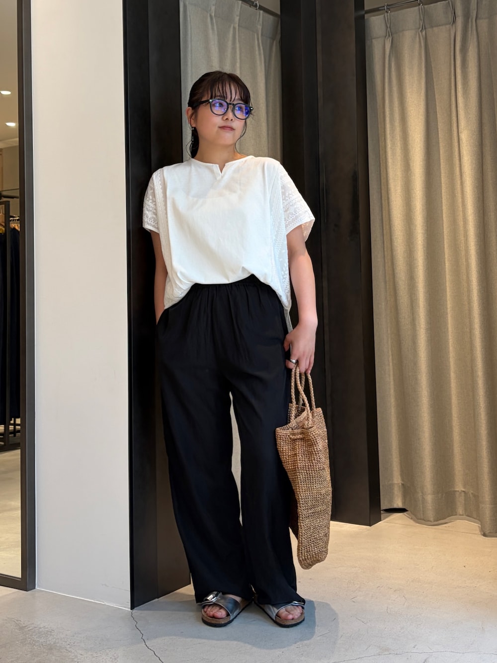 ブラック系のその他パンツ、ホワイト系のその他トップス、ブラウン系のかごバッグを着用したレディースの夏コーディネートの1枚目の写真