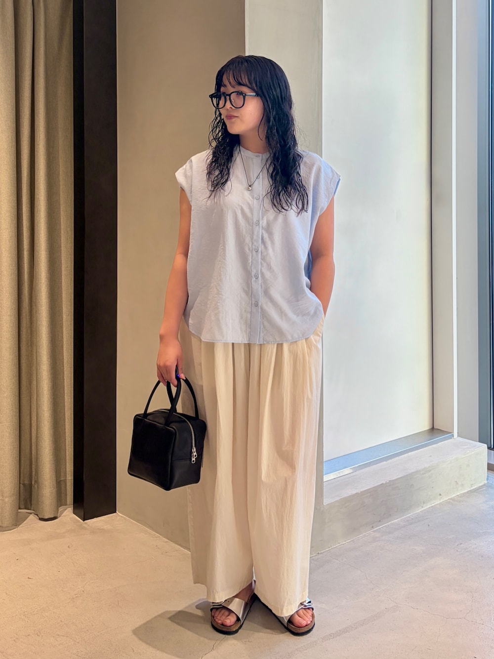 ブルー系のシャツ/ブラウス、ホワイト系のその他パンツ、ブラック系のハンドバッグを着用したレディースの夏コーディネートの1枚目の写真