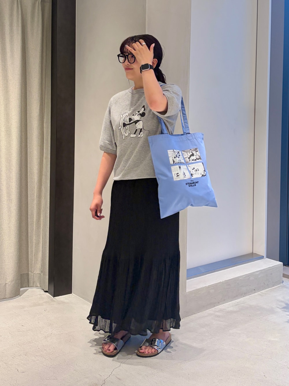 グレー系のシャツ/ブラウス、ブルー系のトートバッグ、ブラック系のスカートを着用したレディースの夏コーディネートの1枚目の写真