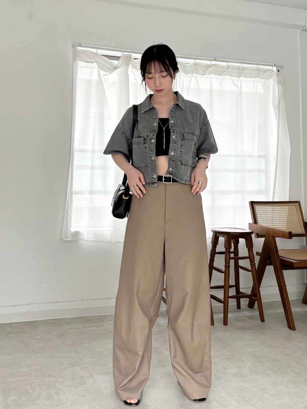 ベージュ系のスラックス、ブラック系のシャツ/ブラウス、ブラック系のチューブトップを着用したレディースの春コーディネートの1枚目の写真