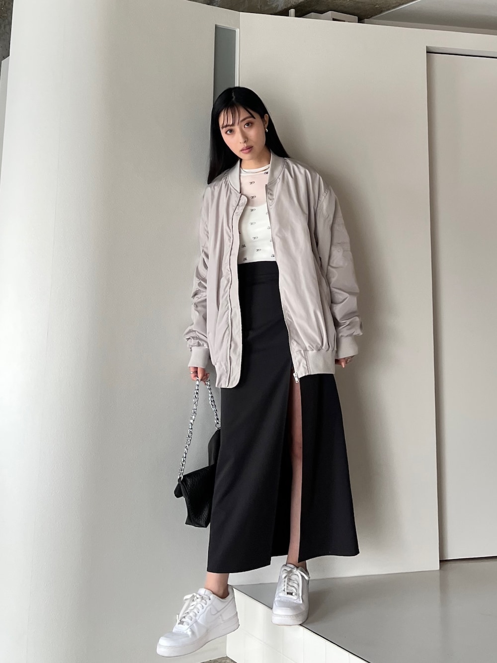 ブラック系のスカート、グレー系のMA-1、ホワイト系のTシャツ/カットソーを着用したレディースの春コーディネートの1枚目の写真