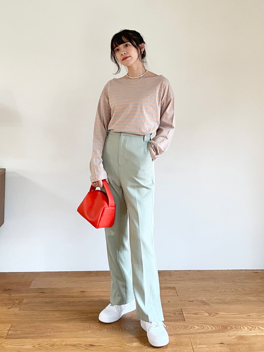 ブルー系のTシャツ/カットソー、グリーン系のスラックス、ホワイト系のスニーカーを着用したレディースの冬コーディネートの1枚目の写真