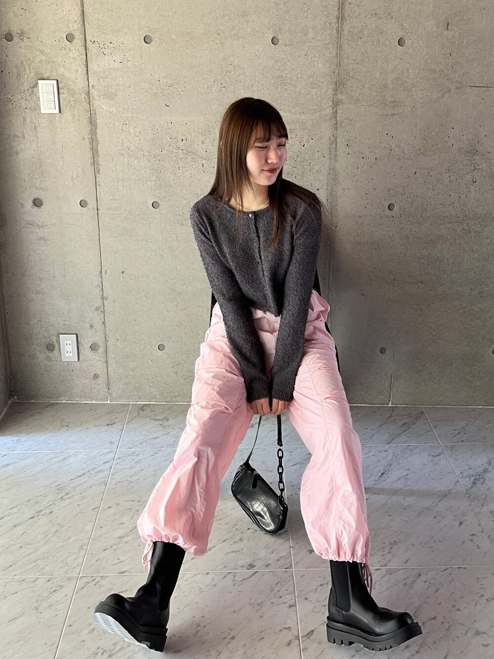 グレー系のカーディガン/ボレロ、ピンク系のカーゴパンツ、ブラック系のブーツを着用したレディースの春コーディネートの1枚目の写真