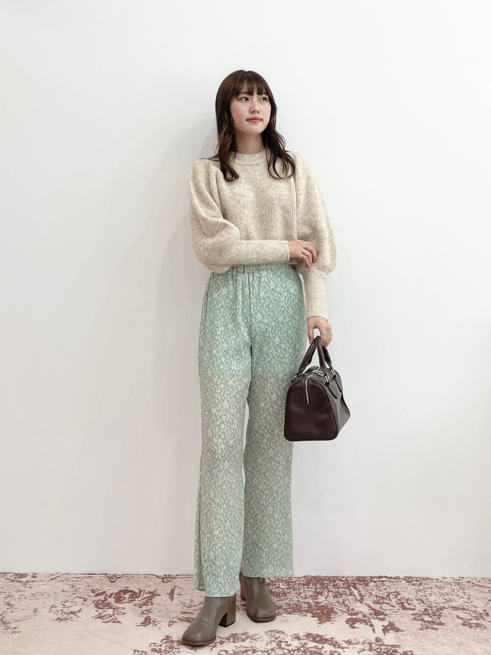 グリーン系のその他パンツ、ブラウン系のボストンバッグ、ブラウン系のブーツを着用したレディースの秋コーディネートの1枚目の写真