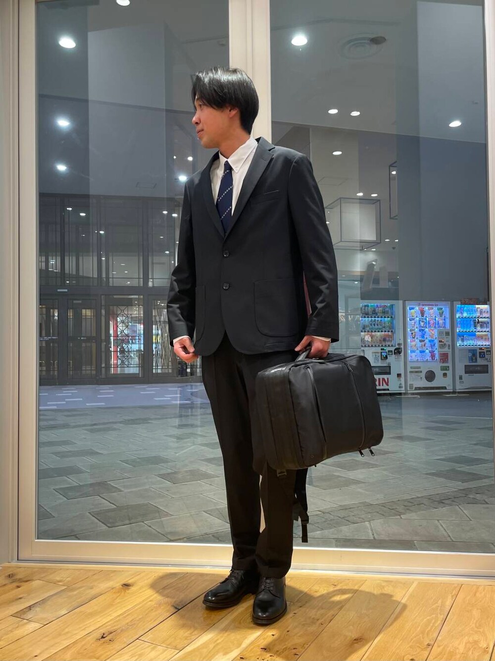 ブラック系のドレスシューズ、ホワイト系のシャツ/ブラウス、ブルー系のスーツジャケットを着用したメンズの冬コーディネートの1枚目の写真