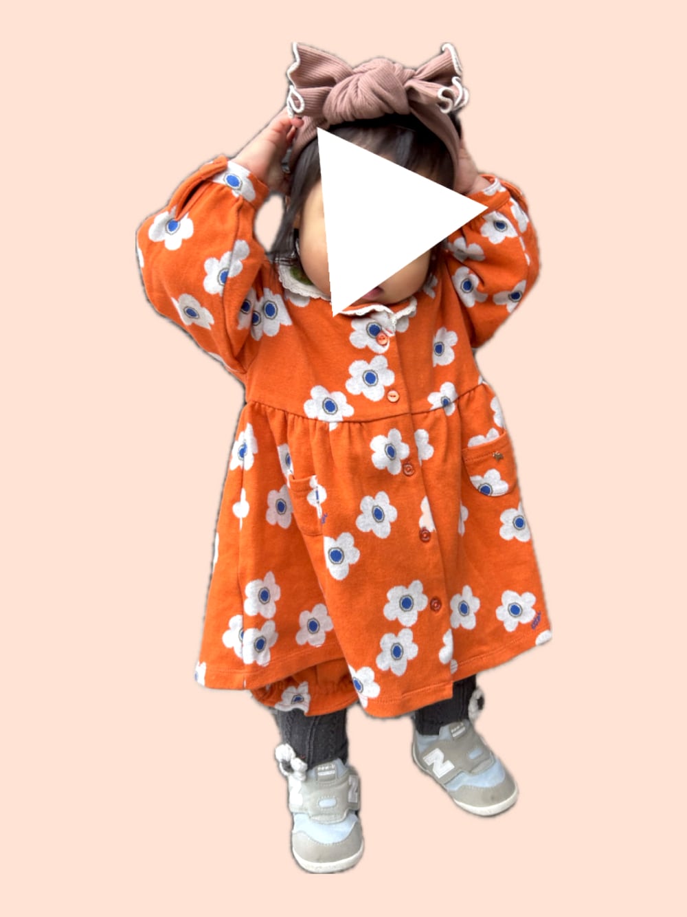 ブルー系のスニーカー、オレンジ系のワンピース、ブラウン系のヘアバンドを着用したキッズの冬コーディネートの1枚目の写真
