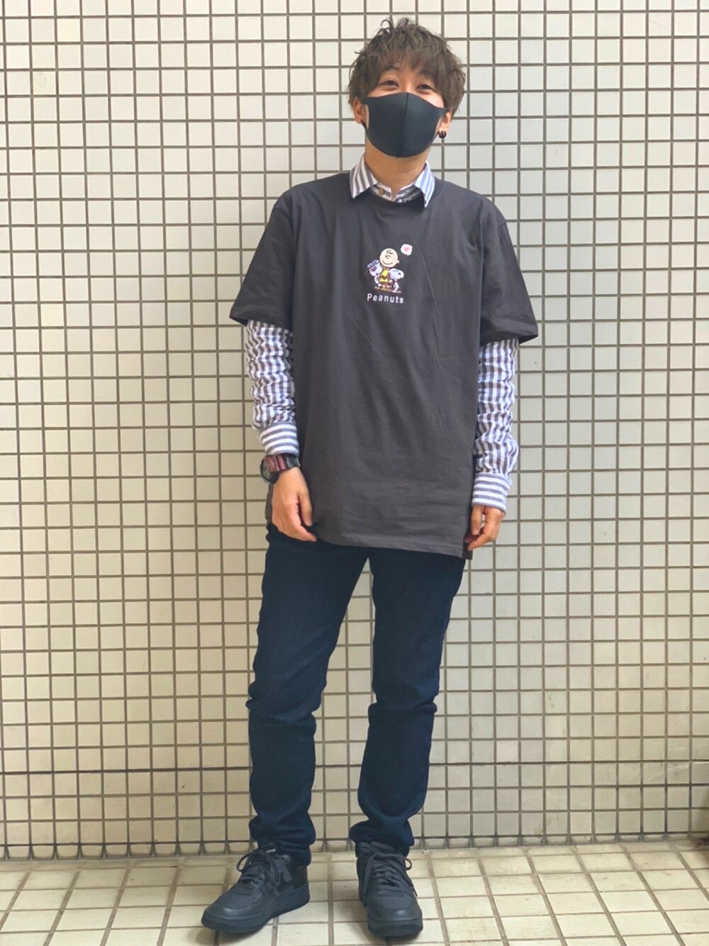ブルー系のデニムパンツ、ブラック系のスニーカー、ブラック系のTシャツ/カットソーを着用したメンズの春コーディネートの1枚目の写真