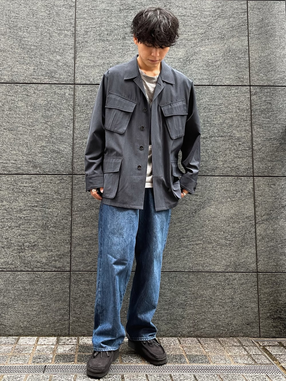 ブルー系のデニムパンツ、ブラック系のモカシン/デッキシューズ、ブルー系のミリタリージャケットを着用したメンズの秋コーディネートの1枚目の写真