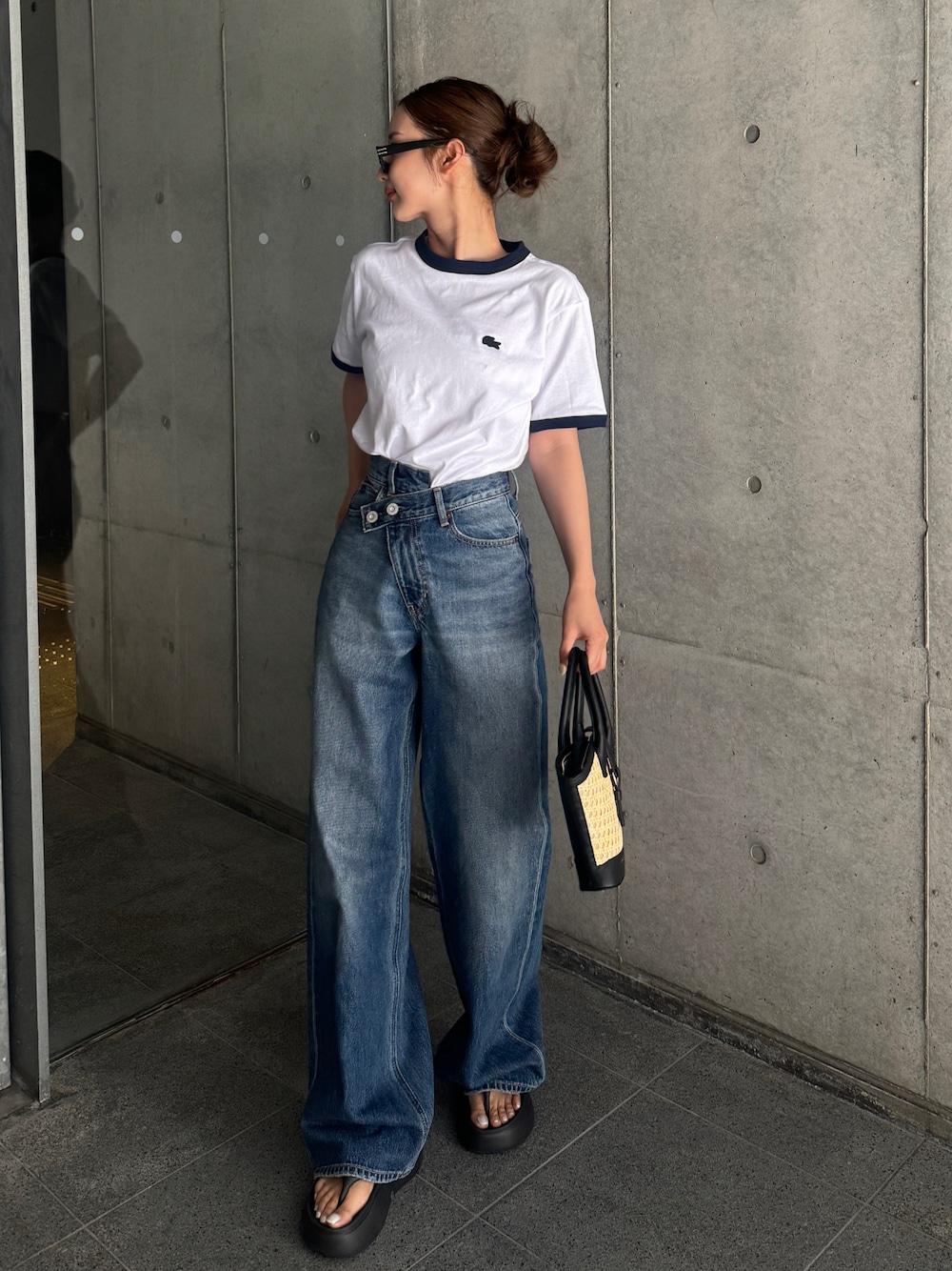 ブルー系のデニムパンツ、ホワイト系のTシャツ/カットソー、ブラック系のサンダルを着用したレディースの春コーディネートの1枚目の写真