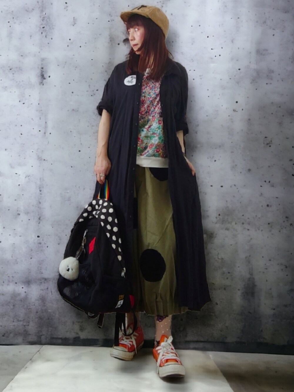 ブラック系のバックパック/リュック、オレンジ系のスニーカー、グリーン系のパンツを着用したレディースの夏コーディネートの1枚目の写真