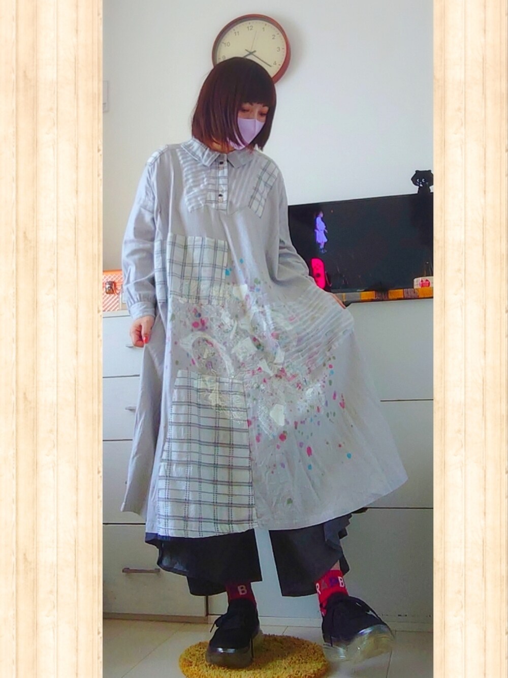 グレー系のワンピース、ブラック系のスニーカー、ブラック系のデニムパンツを着用したレディースの春コーディネートの1枚目の写真