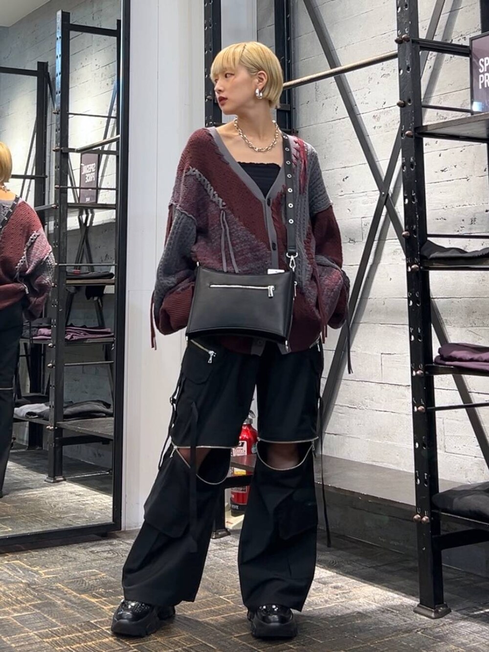 レッド系のカーディガン/ボレロ、ブラック系のカーゴパンツ、ブラック系のスニーカーを着用したレディースの秋コーディネートの1枚目の写真