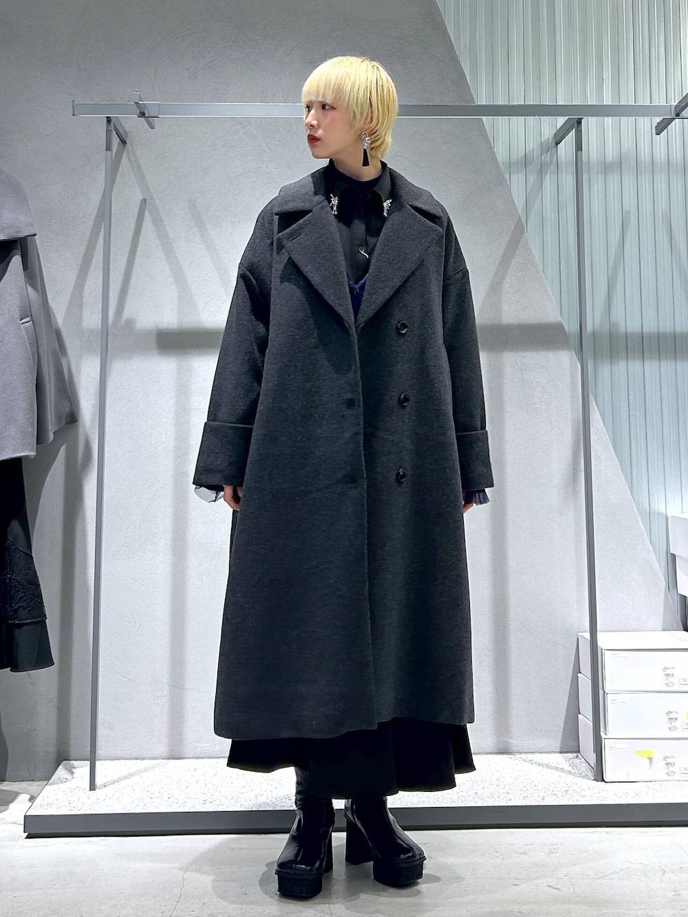 グレー系のチェスターコート、パープル系のカーディガン/ボレロ、グレー系のブーツを着用したレディースの秋コーディネートの1枚目の写真