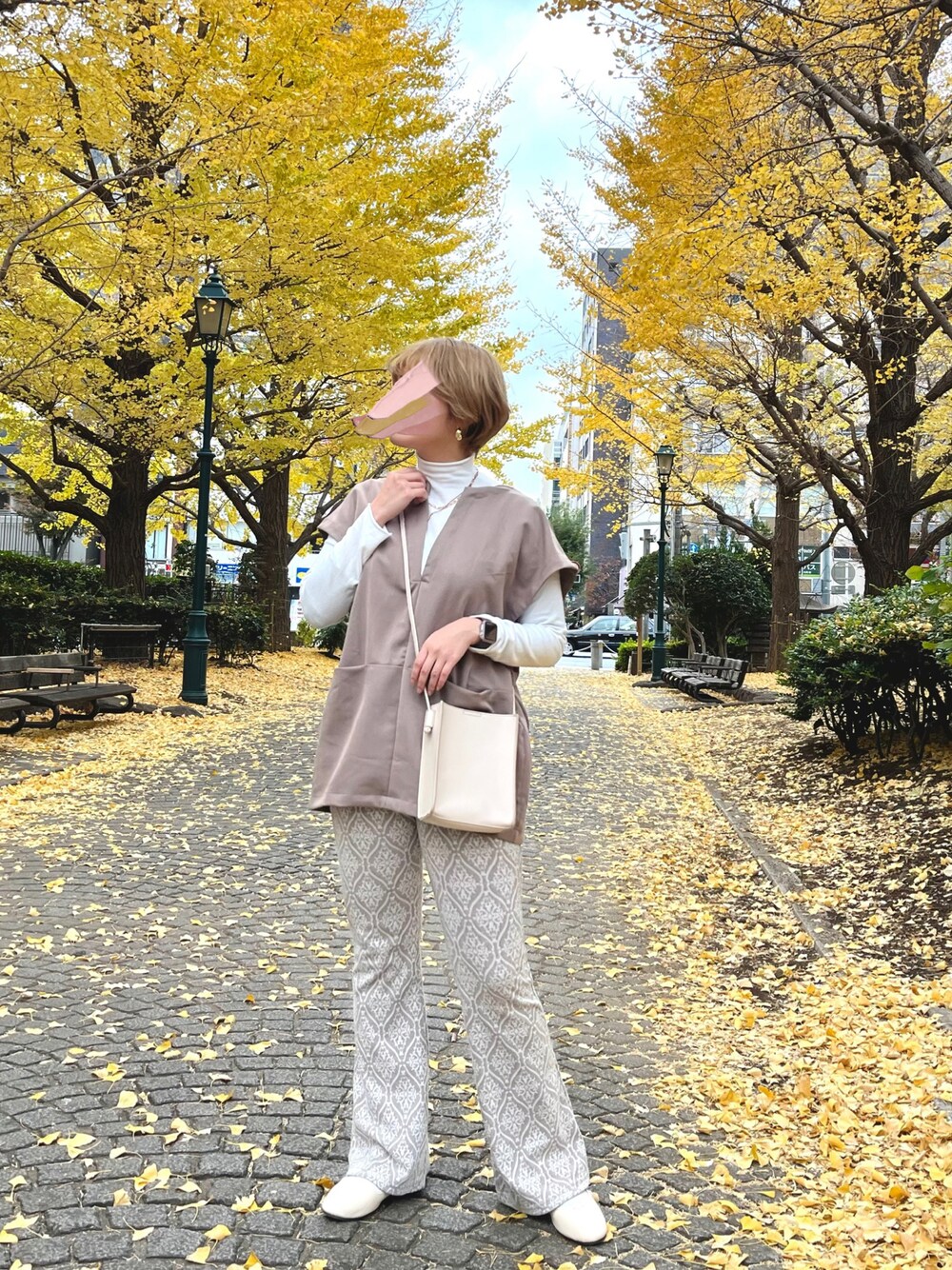 ベージュ系のベスト、ブラウン系のパンツ、ベージュ系のパンプスを着用したレディースの冬コーディネートの1枚目の写真