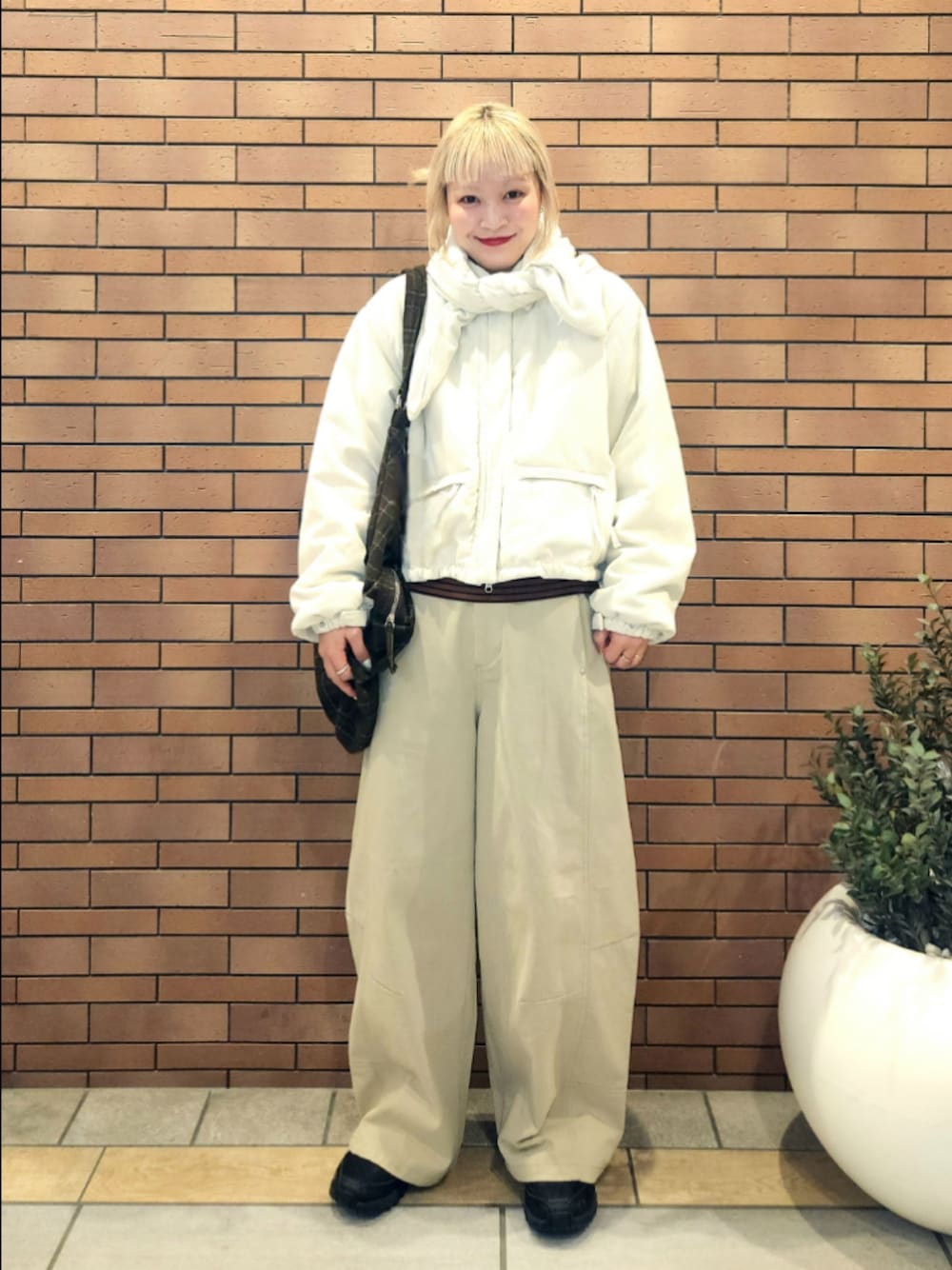 ブラウン系のトートバッグ、ホワイト系のその他アウター、ベージュ系のその他パンツを着用したレディースの秋コーディネートの1枚目の写真