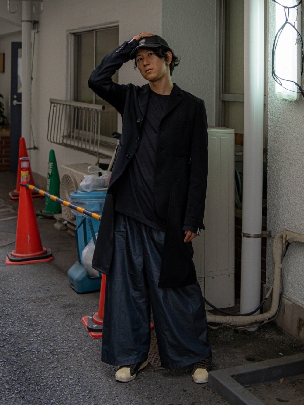 ブラック系のテーラードジャケット、ブラック系のTシャツ/カットソー、グレー系のスラックスを着用したメンズの秋コーディネートの1枚目の写真