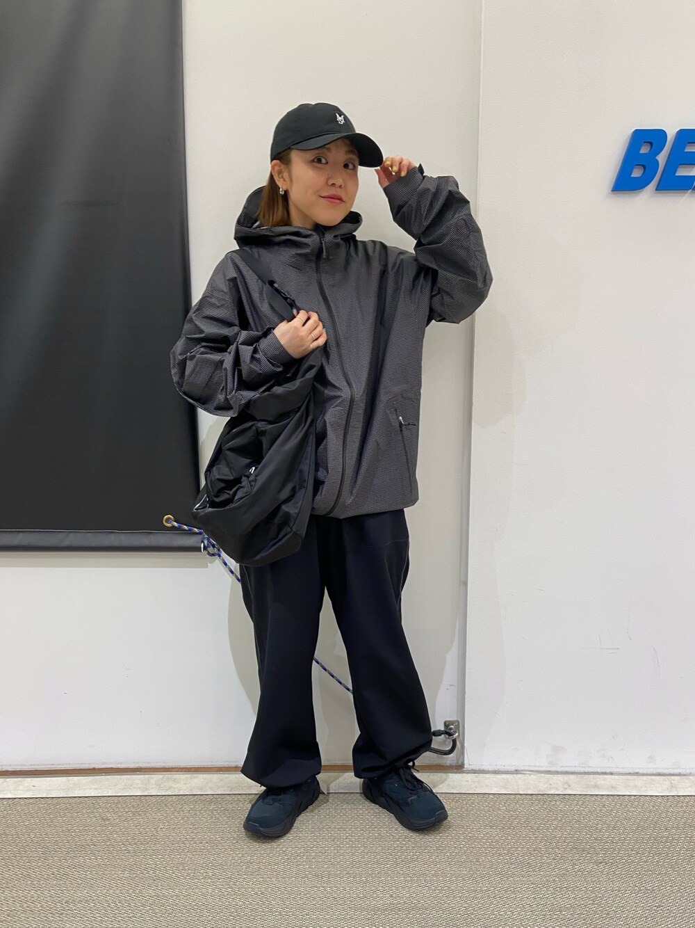 ブラック系のスニーカー、ブラック系のショルダーバッグ、ブラック系のナイロンジャケットを着用したレディースの春コーディネートの1枚目の写真