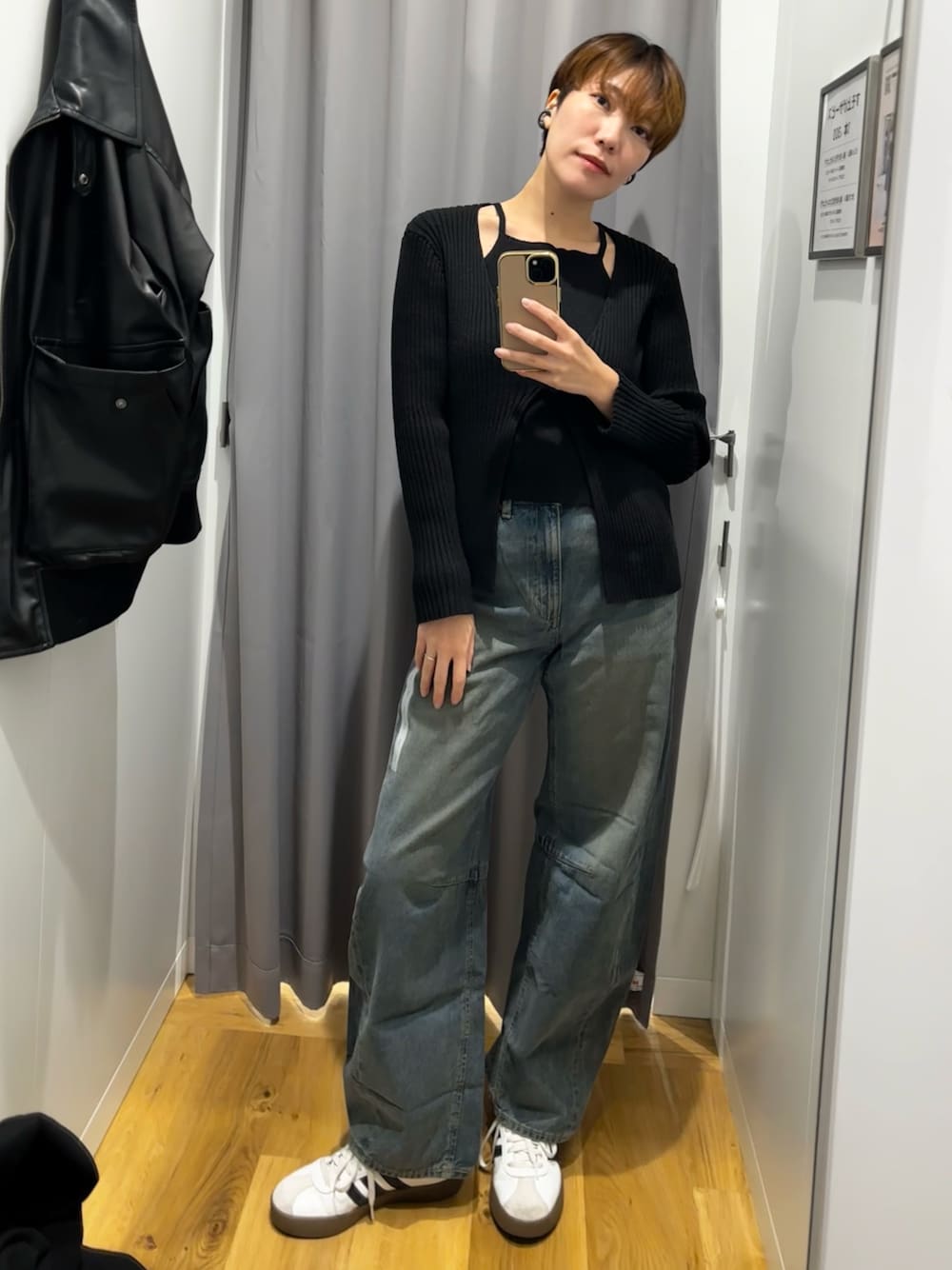 ブルー系のデニムパンツ、ブラック系のニット/セーターを着用したレディースの秋コーディネートの1枚目の写真