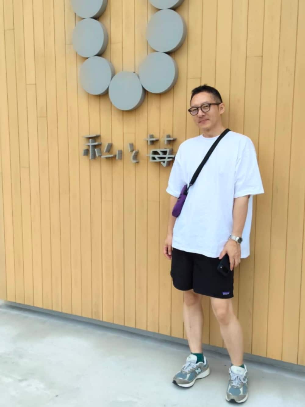 ホワイト系のTシャツ/カットソー、ブラック系のその他パンツ、グレー系のスニーカーを着用したメンズの夏コーディネートの1枚目の写真