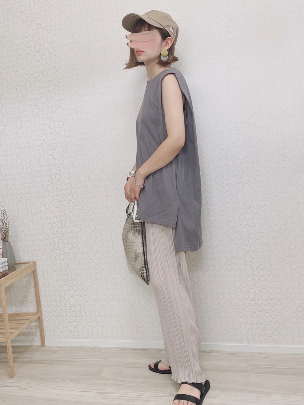 ベージュ系のパンツ、ブラック系のサンダル、ブラック系のショルダーバッグを着用したレディースの夏コーディネートの1枚目の写真