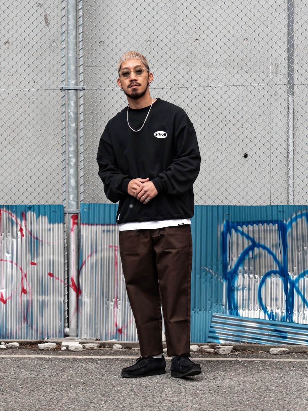 ブラック系のスウェット、ブラウン系のチノパンツを着用したメンズの冬コーディネートの1枚目の写真