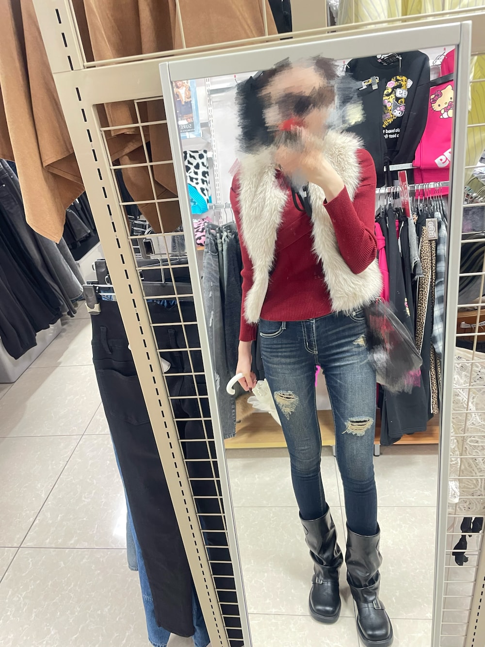 ブルー系のデニムパンツ、ベージュ系のベスト、レッド系のニット/セーターを着用したレディースの秋コーディネートの1枚目の写真