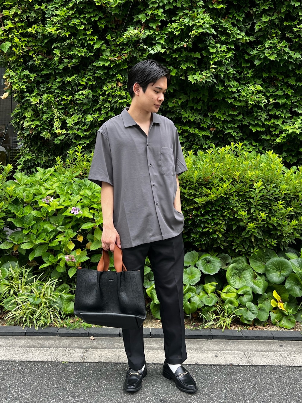 グレー系のシャツ/ブラウス、ブラック系のスラックス、ブラック系のハンドバッグを着用したメンズの夏コーディネートの1枚目の写真