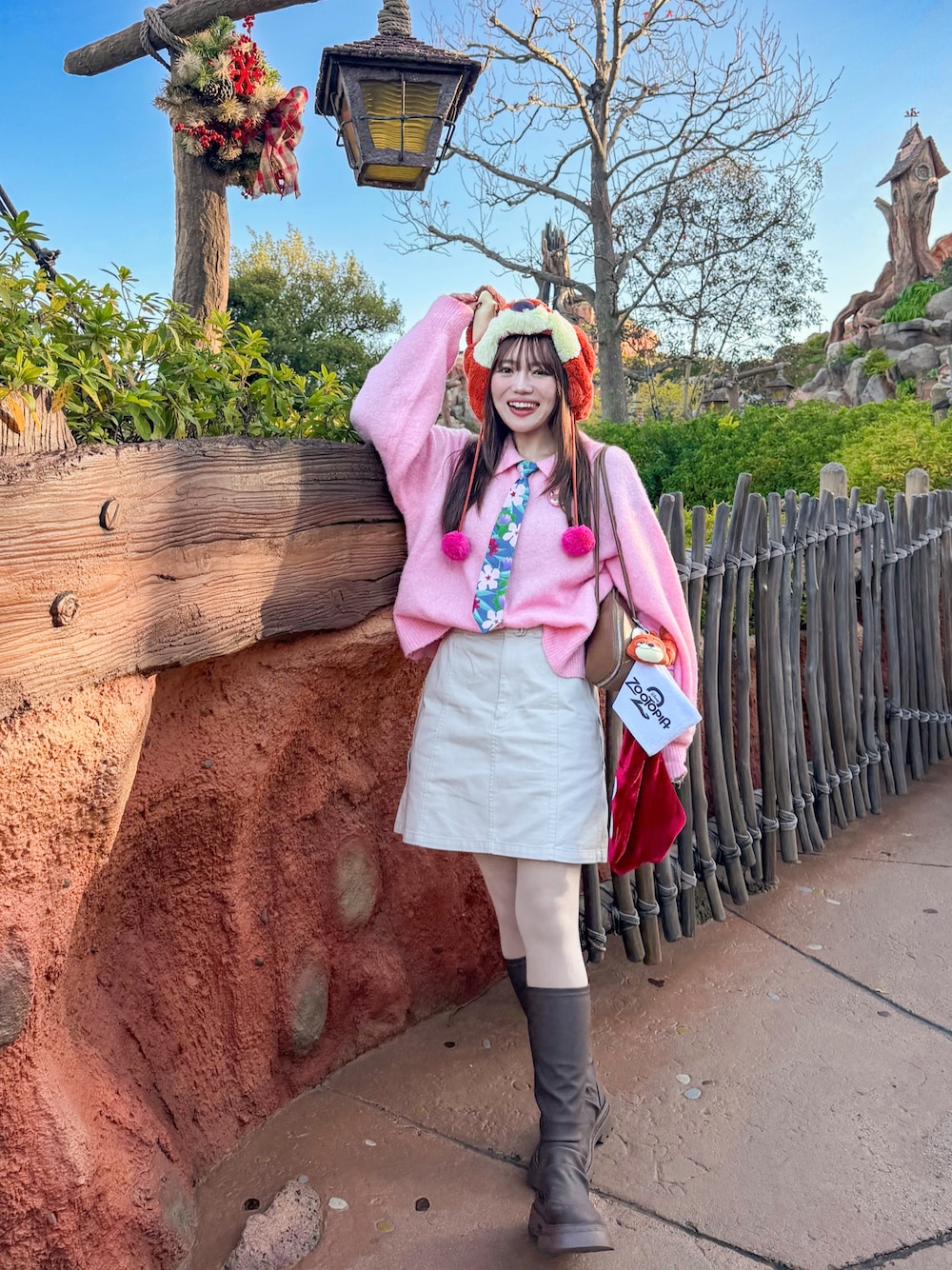 ピンク系のカーディガン/ボレロ、ホワイト系のスカート、ブラウン系のブルゾンを着用したレディースの冬コーディネートの1枚目の写真