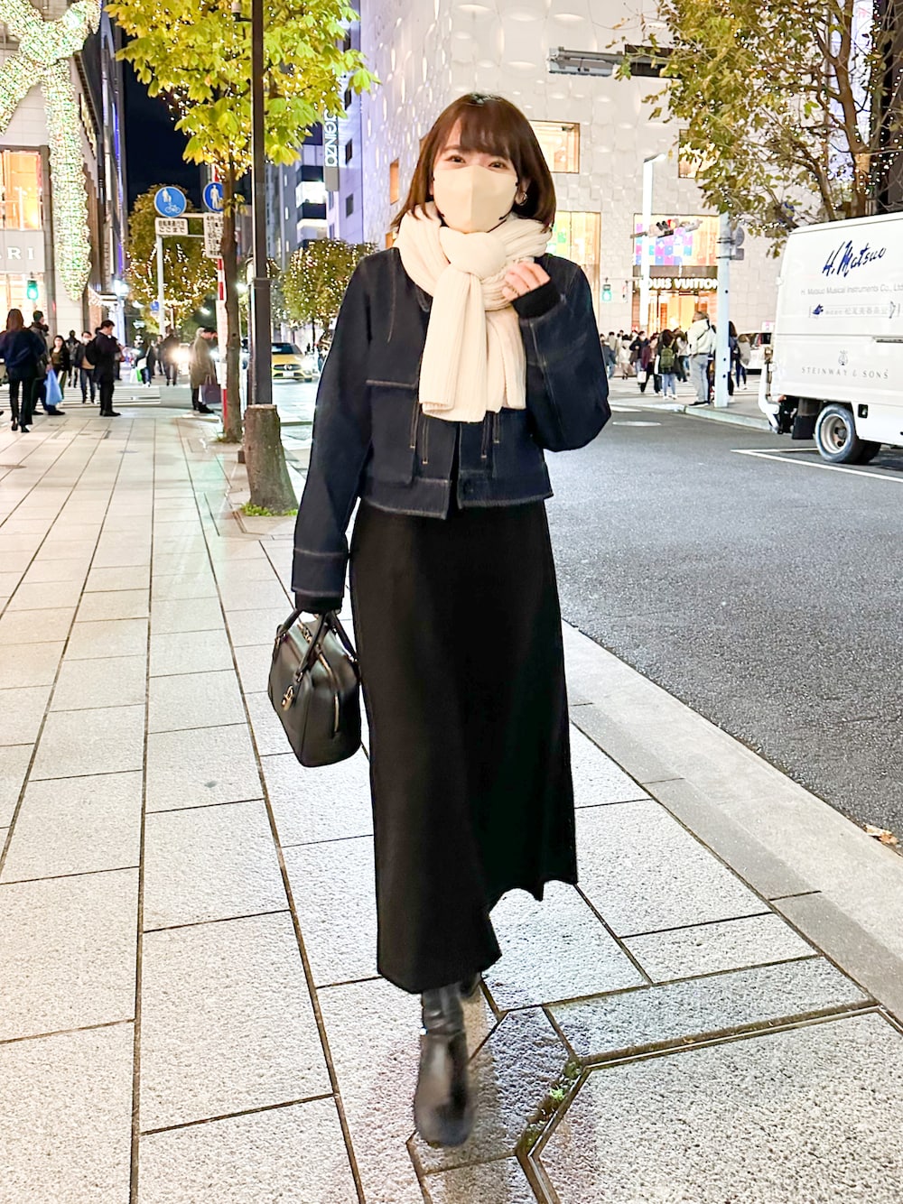 ブルー系のデニムジャケット、ブラック系のワンピース、ブラック系のバッグを着用したレディースの冬コーディネートの1枚目の写真