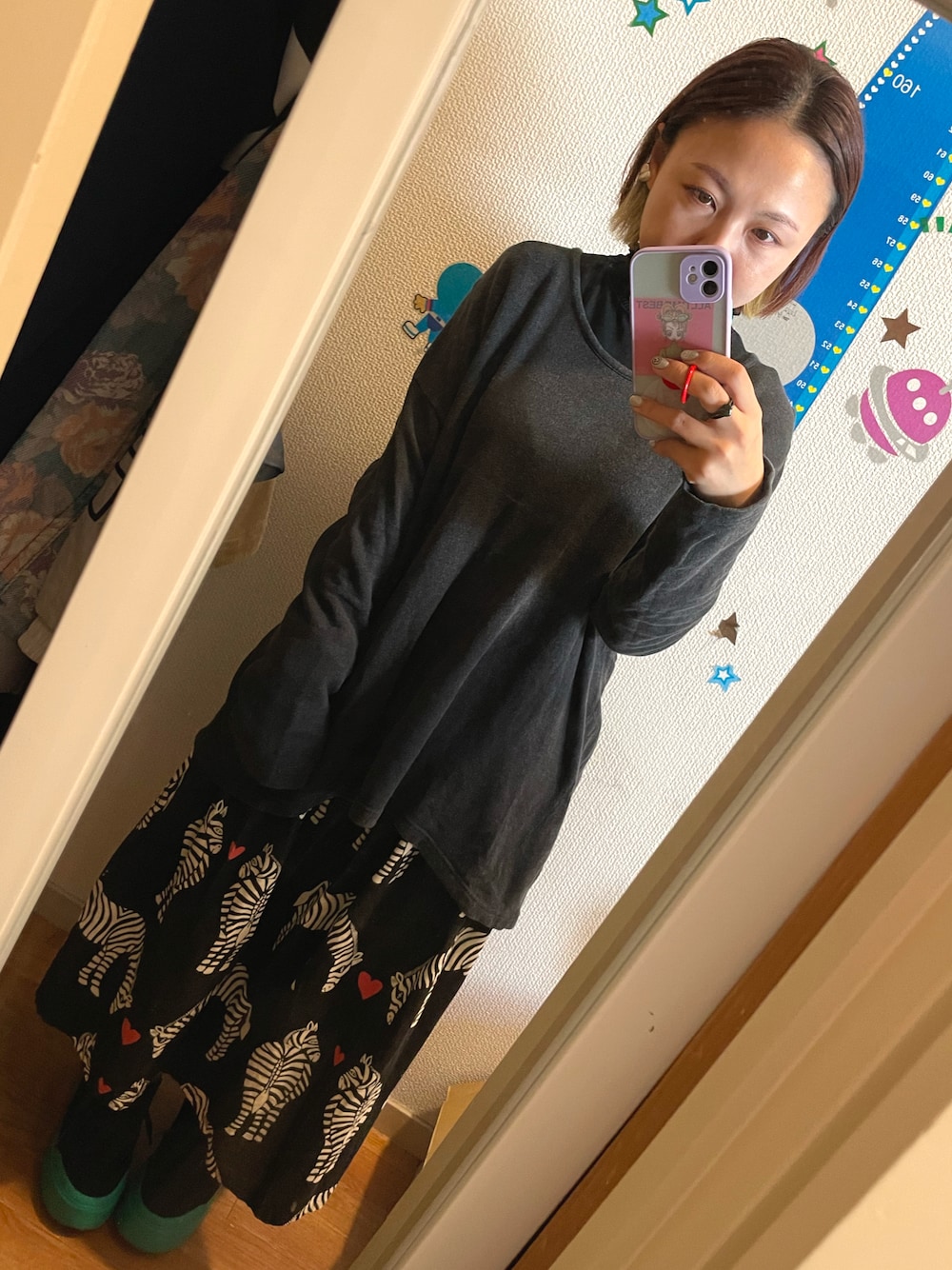 ブラック系のスカート、ブラック系のスニーカーを着用したレディースの秋コーディネートの1枚目の写真