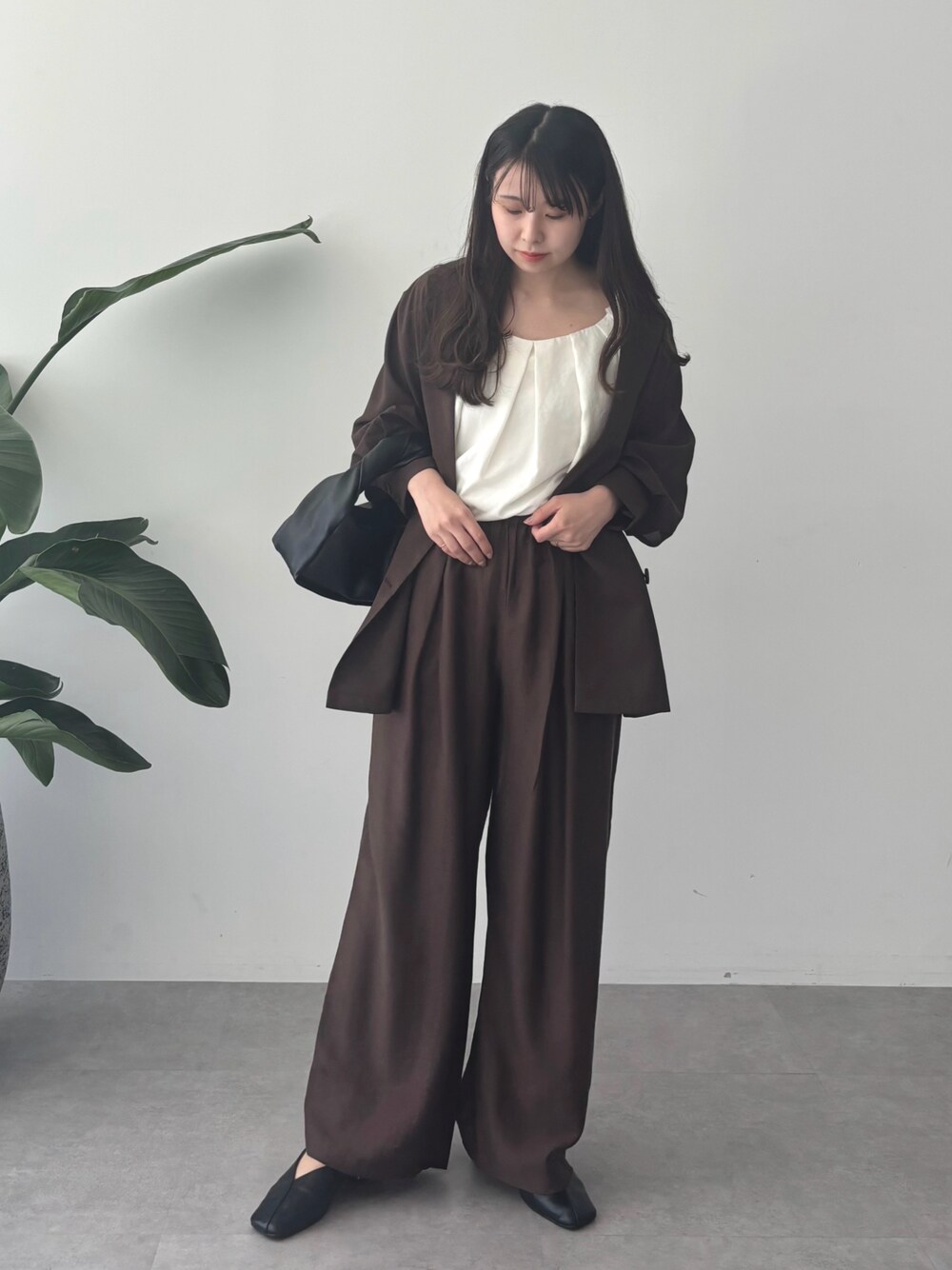 ブラウン系のブルゾン、ブラウン系のその他パンツ、ホワイト系のシャツ/ブラウスを着用したレディースの秋コーディネートの1枚目の写真