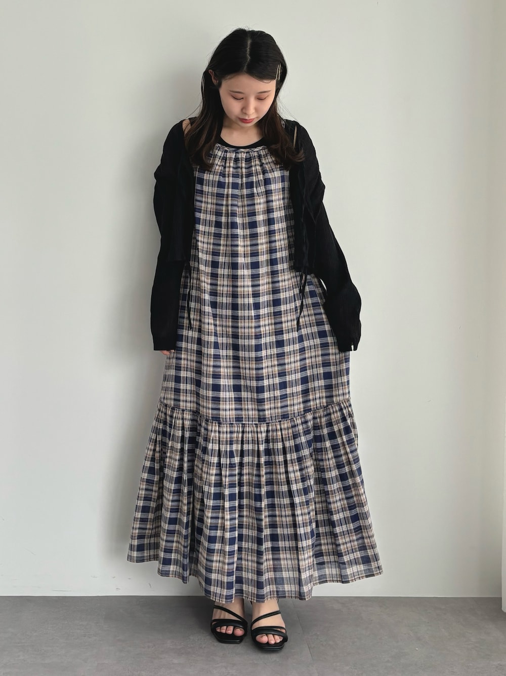 ブルー系のワンピース、ブラック系のシャツ/ブラウスを着用したレディースの春コーディネートの1枚目の写真