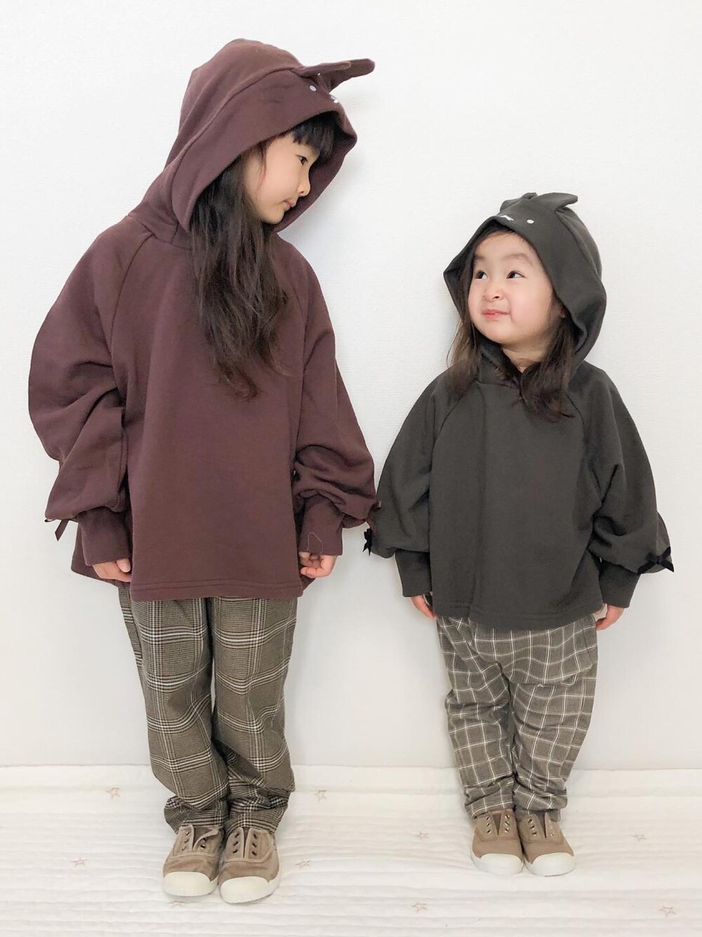 グレー系のパーカー、ブラウン系のパーカー、ブラウン系のパンツを着用したキッズの冬コーディネートの1枚目の写真